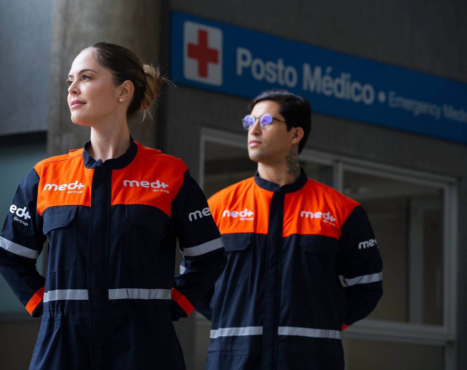 Profissionais da Med+ de uniforme em frente a um posto médico